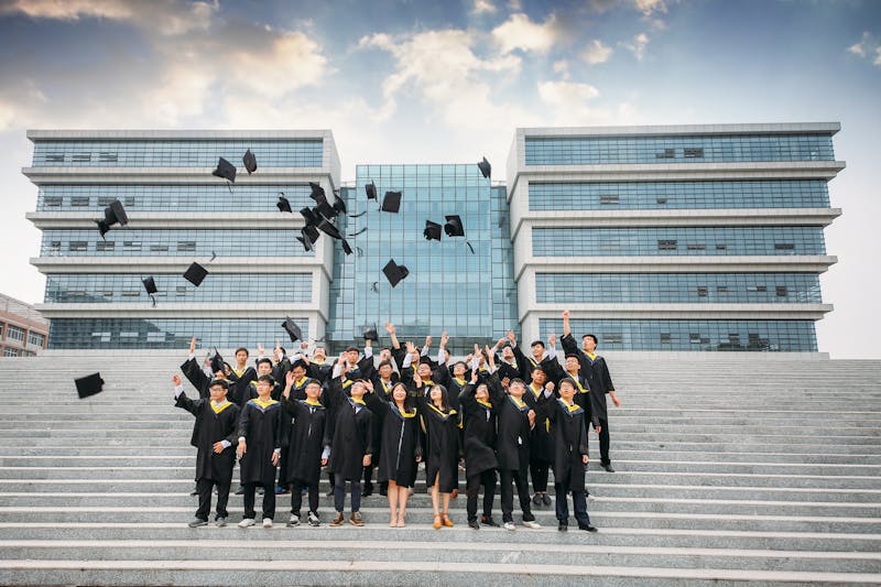 University graduates tossing their caps in celebration outside a modern campus building