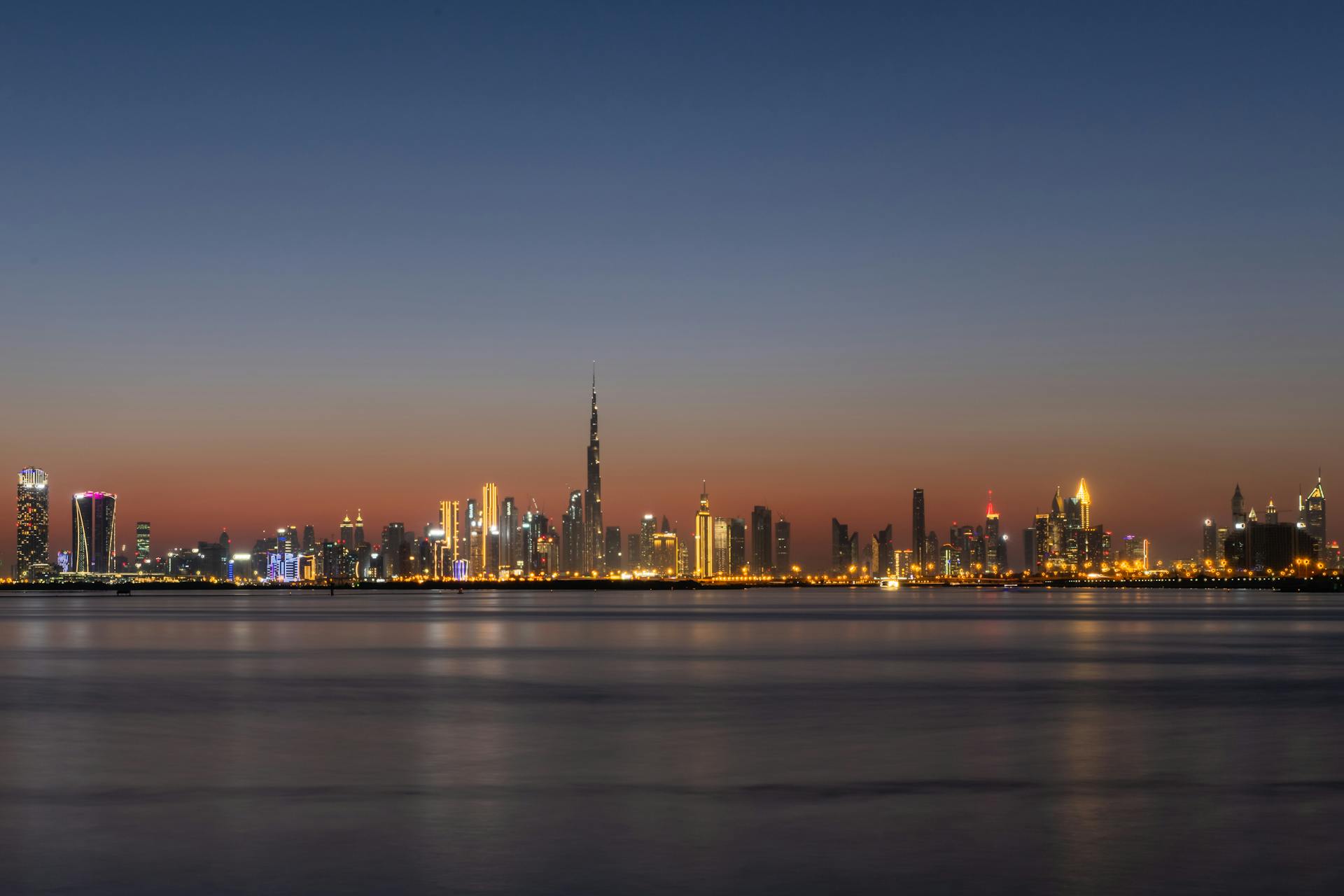 Dubai skyline at dusk with the Burj Khalifa reflected over the water