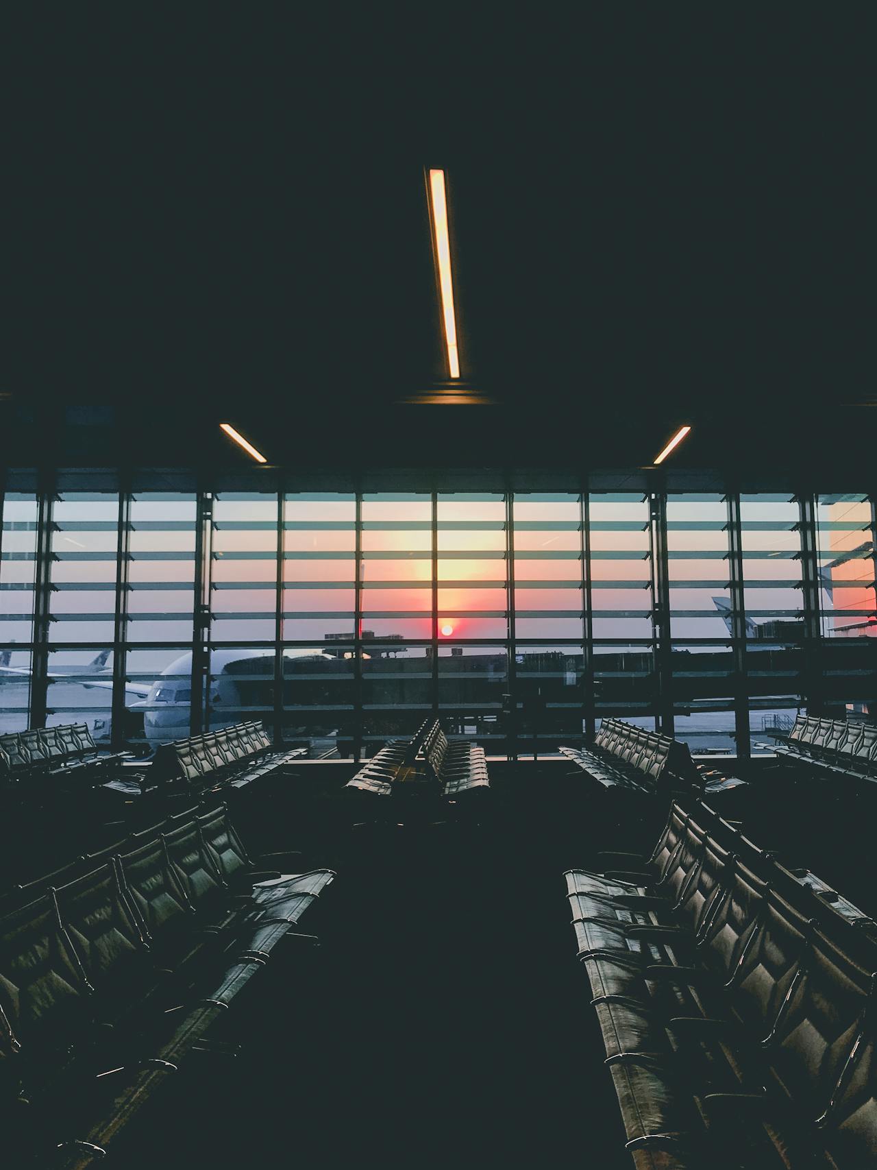 An airport terminal at sunset with aircraft on the tarmac